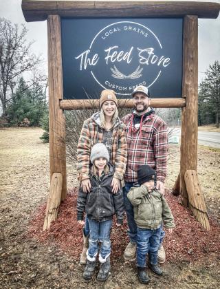 Alysia (left) and Troy (right) Govitz and their two children outside of their new business, The Feed Store located at 2461 S. M-30.