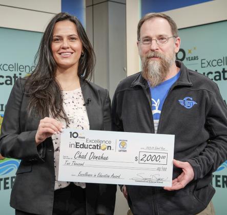 Lottery Commissioner, Suzanna Shkreli (left) presented the Excellence in Education check to Chad Donahue (right). MICHIGAN LOTTERY