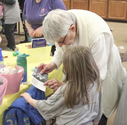 Rev. Karen Blatt helps a Kid’s Club kid build an Easter basket.