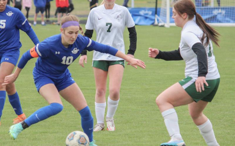 Anna Seebeck and team gather for a picture after last Wednesday’s game against Roscommon, celebrating Seebeck’s 100th career goal. Inset photo, Anna Seebeck displays excellent footwork, weaving the ball through defenders during Gladwin’s 6-1 victory over the Clare Pioneers on April 24.