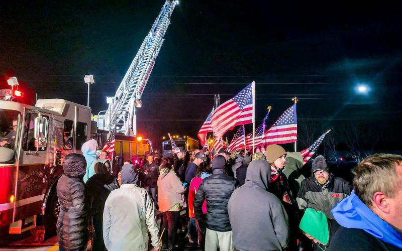The Bangor Township Fire Department had a ladder truck waving the American Flag over the North Union overpass near Bay City on Thursday night (April 6). The overpass was closed to traffic during this time. Inset photo, U.S. Army Specialist Braden Peltier. PHOTO PROVIDED BY WHITNEY ALBERTSON
