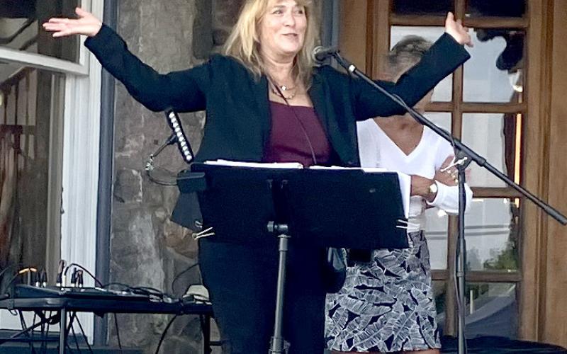 Char Stone House owner Sheryl Sacry welcomes the crowd and brings on the band Thursday at the new restaurant’s first event.