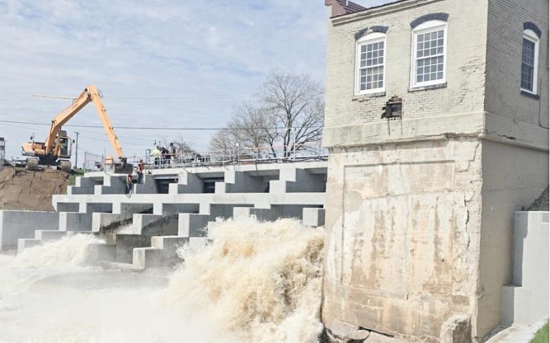 Workers are pictured attempting to remove a log at the Beaverton Dam.