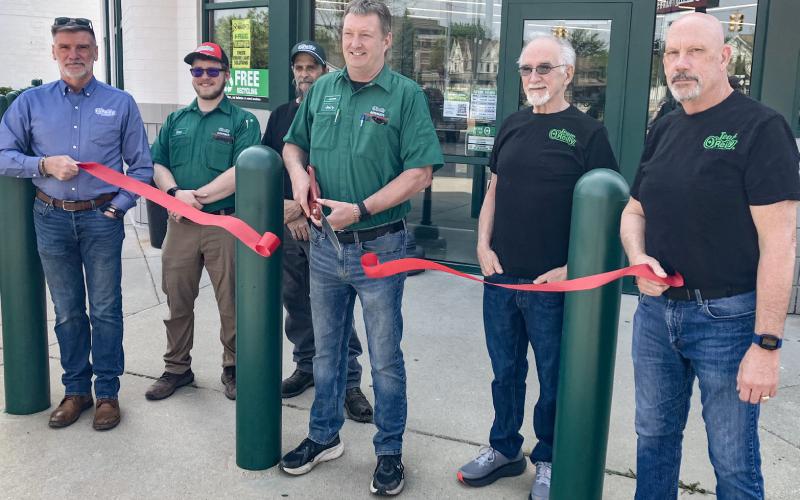 O’Reilly’s Auto Parts Manager Jerry Landenberger makes the opening of the new store at 120 E. Cedar Ave. official by cutting the ribbon with a group of O’Reilly’s employees Sunday morning.