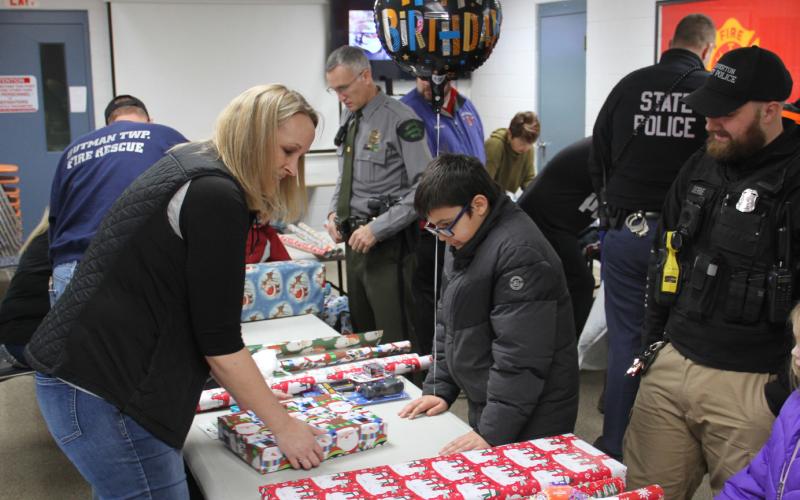 Spencer, 11, celebrated his birthday shopping with his hero, Beaverton City Police Officer Sean Derde. With the help of Crime Stoppers volunteers, he waits for his gifts to be wrapped.