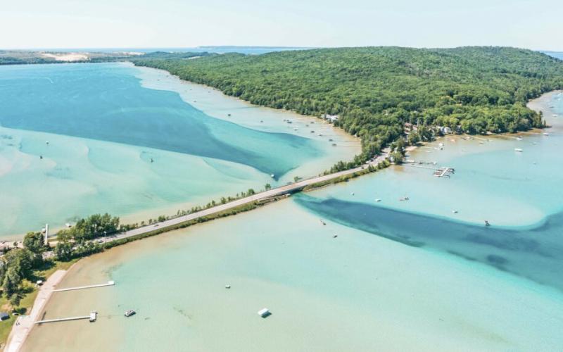 A scenic overhead view of a bright blue Glen Lake. PURE MICHIGAN