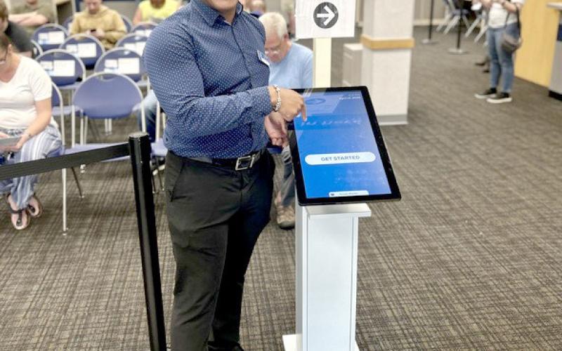 Xavier Henderson, branch manager of the Portage office, smiles for a photo at the check-in and booking station.