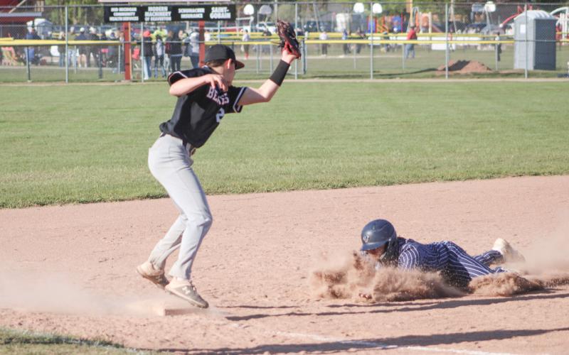 Beaverton’s Parker Woods is a bit late with the tag on a sliding Standish runner at third base during last week’s doubleheader.