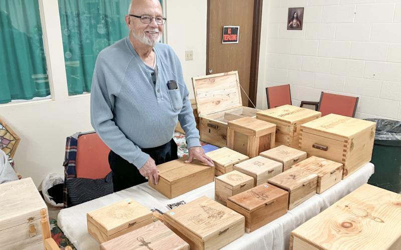 Gladwin County Commissioner Tom Winarski mans his table at the Sacred Heart Bazaar Saturday.