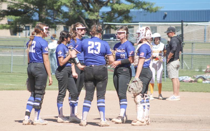 At left, Audrey Andrist and the Beaverton softball team checked out for the year with a hard-fought 10-8 loss to Farwell Saturday in the district tourney at Meridian. At right, the Gladwin softball team has a meeting at the mound to address the impending end of the season during Ogemaw’s final rally in the fourth inning Saturday.