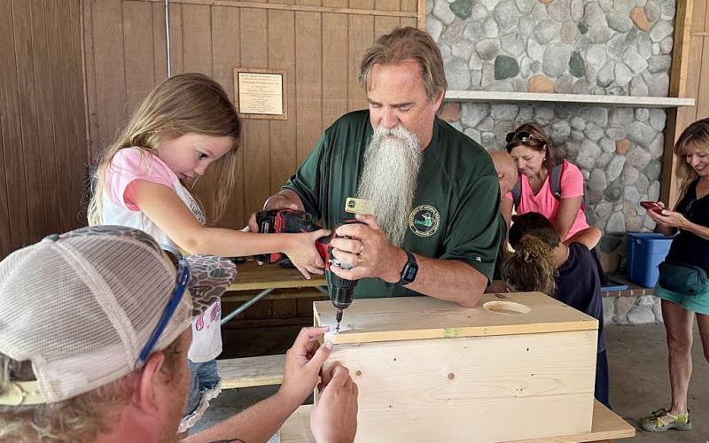 DNR staff help children build wood duck boxes to take home and install in trees near wetlands. These boxes have helped restore wood duck populations throughout Michigan.