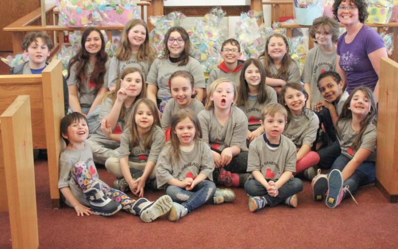 Pastor Emily Olsen, Kid’s Club kids, and adult voulnteers build 42 Easter baskets at Christ the King Lutheran Church. Inset, several finished Easter baskets.
