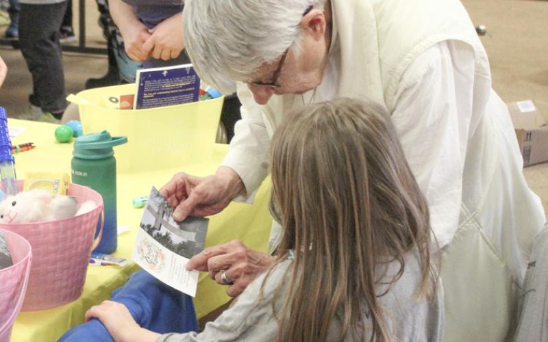 Rev. Karen Blatt helps a Kid’s Club kid build an Easter basket.