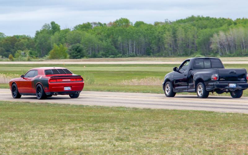 Zach Gradowski (left) races his Dodge Challenger during the Thunder on the Strip drag race event on Saturday, May 20 at the Gladwin Zettel Memorial Airport.