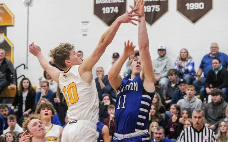 Gladwin’s Nick Wheeler shots from long distance as Ogemaw Heights defender Sawyer Dack tries to block.