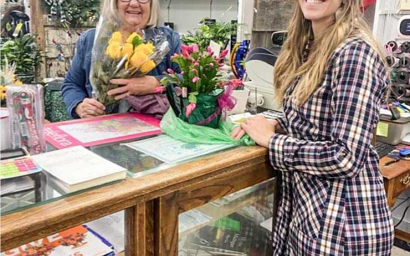 Customer Cyndi Adamec receiving roses from Leah Mead.
