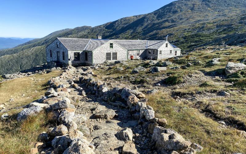 Pictured is The Lake of the Clouds Hut, a rental hut and lodge for hikers operated by the Appalachian Mountain Club. Inset photo, at left, Loren McLaughlin, and at right, John Del Percio, at the peak of Mount Washington (6,288.2 feet) in New Hampshire.