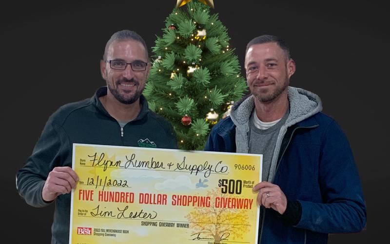 Jerram Dee (left) presents the $500 shopping giveaway check to Tim Lester of Gladwin, one of the two winners.