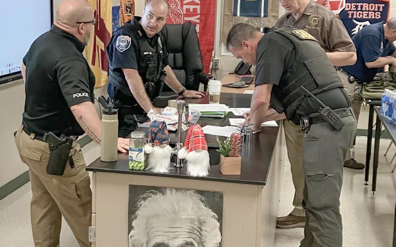Gladwin County Undersheriff James Cuddie signs in for an active assailant training session at Gladwin Junior High Thursday.