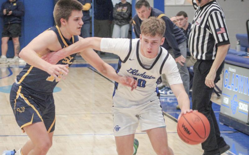 At left, Liz Winchester runs the court against Standish on Hall of Fame Night Friday at Gladwin. At right, Jacob Pahl wards off the defense on his way to scoring 37 points Friday night when Gladwin won the JPC Division 1 championship.