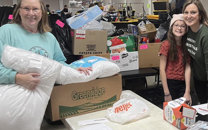 Pictured are volunteers organizing gifts during Christmas Kindness.