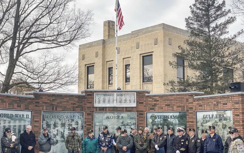 Veterans during the American Legion’s Veterans Day program standing in front of their respective memorials.