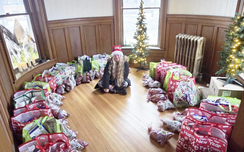 Kortni Brewer, Marketing Manager and designated Christmas Elf at Char Stone House, poses with the Merry Meals that were distributed to local families in need Monday by the business.