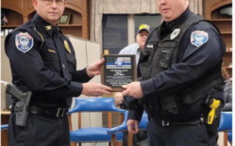 Gladwin City Police Chief Eric Killian (left) presents Officer Aaron Miller with a Life Saving Award.
