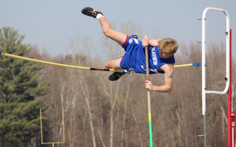 High in the air, Gladwin looks to vault over the pole without knocking it over. Inset photo, Gladwin closely follows Houghton Lake as they compete in hurdle competition.
