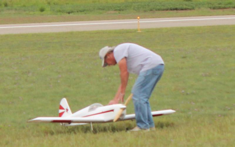Above, planes line up for an opportunity to fly. Bottom left, planes are maintained throughout the event. Bottom right, plane being prepared for flight.