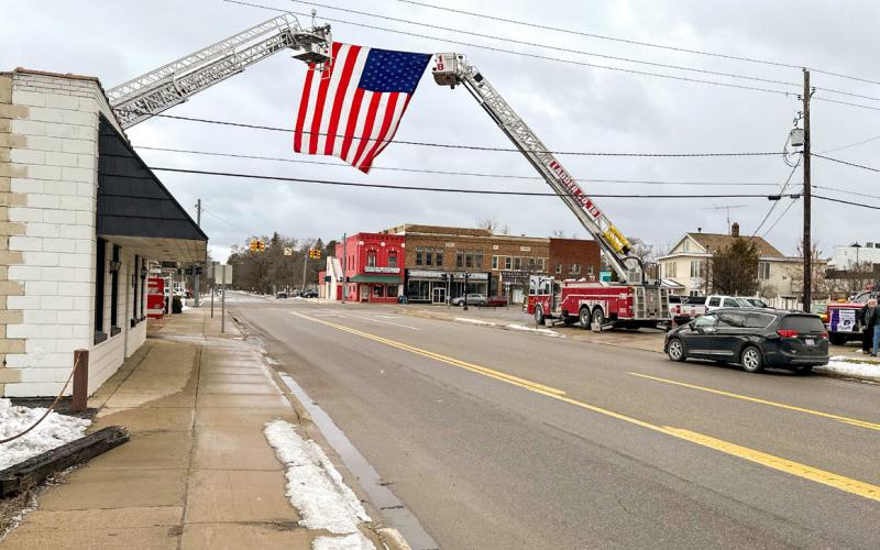 An American Flag waves high above Silverleaf St. in Gladwin honoring the late Alan Vincent during the funeral service.