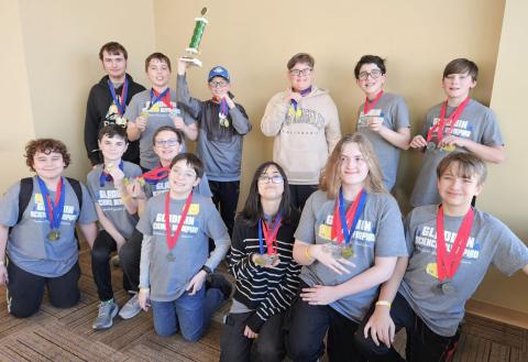 The team posing with their second place trophy after a long day of competing.