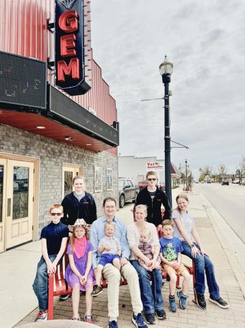 Ian and Tiffany Burgess pose with some potential employees in front of the Beaverton Gem, the theater which they recently purchased.