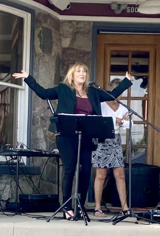 Char Stone House owner Sheryl Sacry welcomes the crowd and brings on the band Thursday at the new restaurant’s first event.