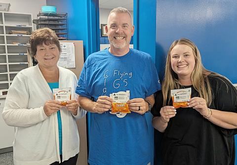 Holding their snack appreciation bags are Gladwin Intermediate School Secretary, Jen Slabic; GIS Principal, Bryan Randle; and GIS Librarian and Special Education Secretary, Ciara Robinette.