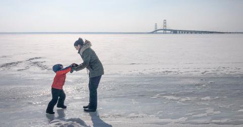 Frozen bodies of water should be checked carefully before braving the ice. While there is no perfectly reliable method to determine if ice is safe, you can use a spud, needle bar or auger to test the thickness and quality of ice. Inset photo: always wear ice picks secured to your chest so they are within easy reach in case you break through the ice.