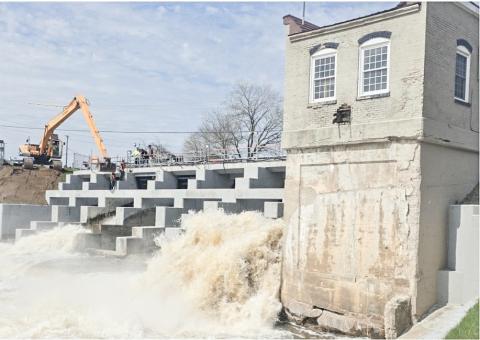 Workers are pictured attempting to remove a log at the Beaverton Dam.