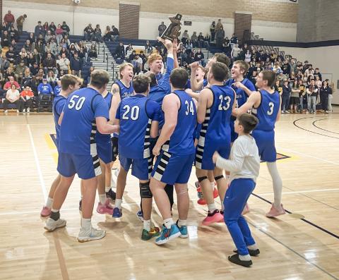 The Gladwin basketball team stormed the court to celebrate with the trophy after winning the Division 2 District Tournament at Shepherd Friday night.