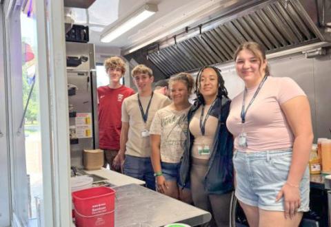 A group of campers from 2025 LAB Week, where students designed and pitched their own food truck concepts while learning how businesses differentiate themselves through branding, customer experience, pricing, and location strategy.