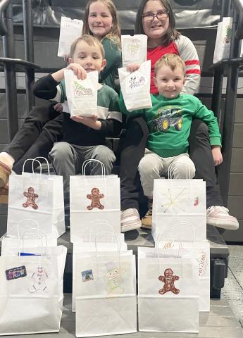Pictured are Caroline, Lily, Logan and Connor, the spirited children of Tyler and Angela McLaren, display their handiwork after decorating gift bags for homebound Gladwin County residents. They are the grandchildren of Tina and Mike Haines, Kim and Pat Savage, and Mark and Amy Baker, all proud Beaverton residents.