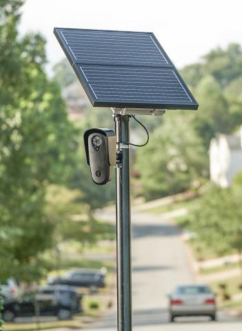 A solar-powered license plate reader mounted on a pole. FLOCK SAFET