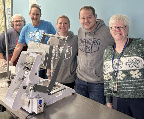 Team members help package meals at Antler Arms Dining Center.