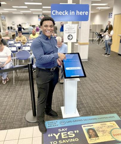 Xavier Henderson, branch manager of the Portage office, smiles for a photo at the check-in and booking station.