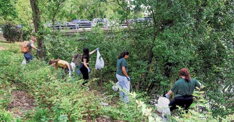 Volunteers clean up garbage along the Red Cedar River in East Lansing. MICHIGAN STATE UNIVERSITY