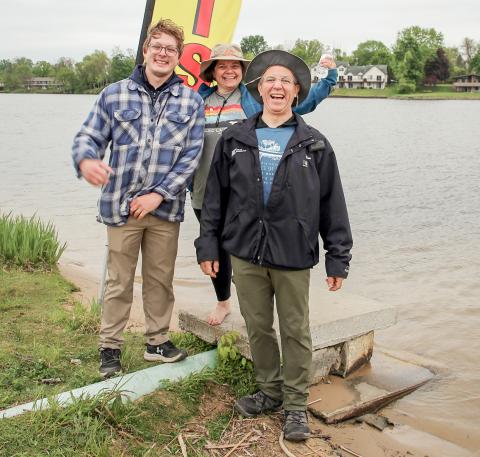 Tristan Hewitt and Marah Ranke of the Gladwin County Conservation District celebrate with winner Jim Looker at the end of the River Race of Two Cities at Ross Lake Park.