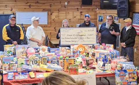 Shelly and Justin of Harper Strong accept a check and a table full of toys from Secord Lake Eagles President Ward Komer and the Aerie’s Executive Board during a ceremony at the club on Sunday.
