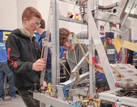 Noah Burgess and Dylan Northrup work on assembling the BeaverTech robot prior to last weekend’s robotics competition at Midland Dow.