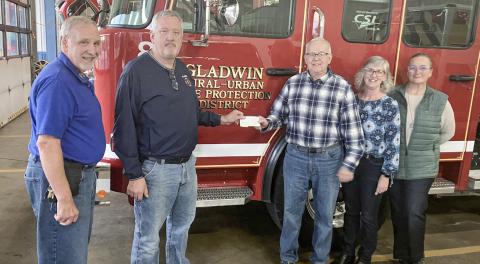 Pastor David Sprang and John Caffrey of the Gladwin Rural Urban Fire Department present a check for $1,000 to Kevin Brott, Lanette Morgan and Candace Pennell of the New Dawn Shelter. The funds for the donation were raised at the department’s golf outing in August.