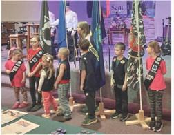 Members of the Road Rangers and the Girls’ Ministry youth groups at Gladwin Assembly of God stand with the flags of the different branches of the service at Sunday’s salute to Vietnam veterans.