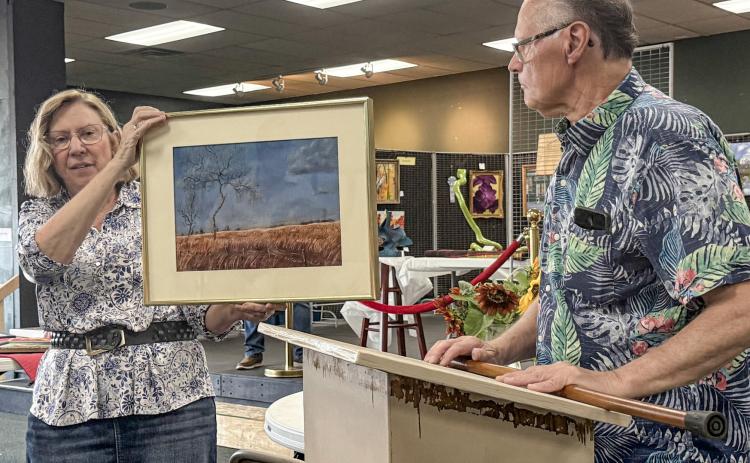 Jan Berg-Rezmer holds Connie Maedel Diehl’s painting while 2025 Art Judge Lynn Morgan comments as to why he chose the pastel titled, Forgotten Pasture, for a third place award in the General Art category.